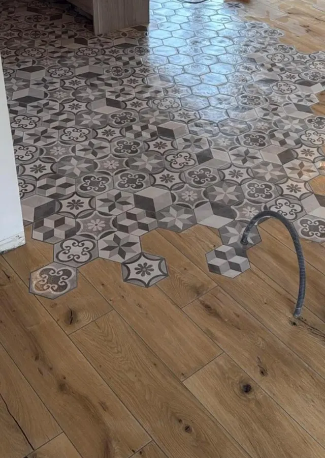 Carreaux hexagonaux effet ciment à motifs, fondus dans un sol imitation parquet